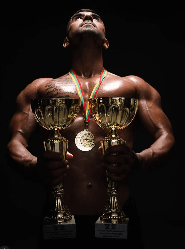 Edvardas Klimas holding his championship trophies and medal